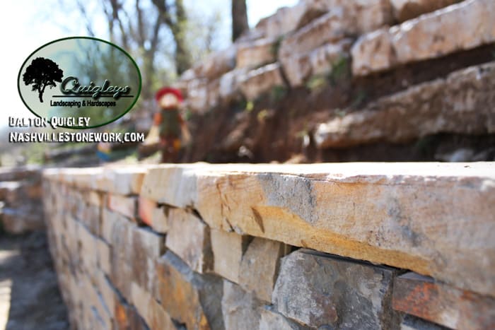 Block retaining wall with natural stone veneer with cap and three piece paver Nashville